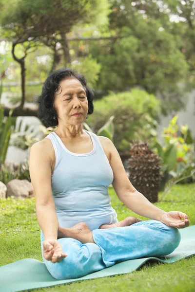 stock image Senior woman doing meditation for yoga