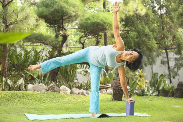 stock image Senior old woman doing yoga in park