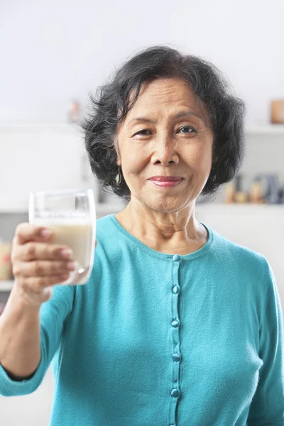 Seniorin hält Glas Milch in der Hand — Stockfoto