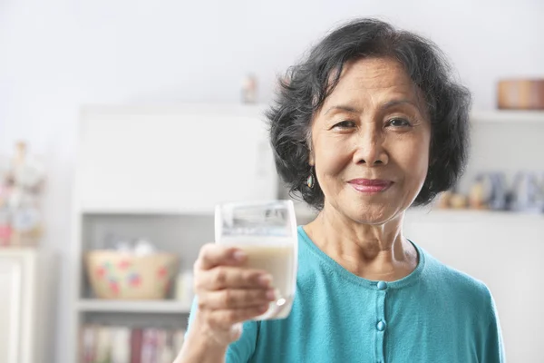 Femme âgée tenant un verre de lait — Photo