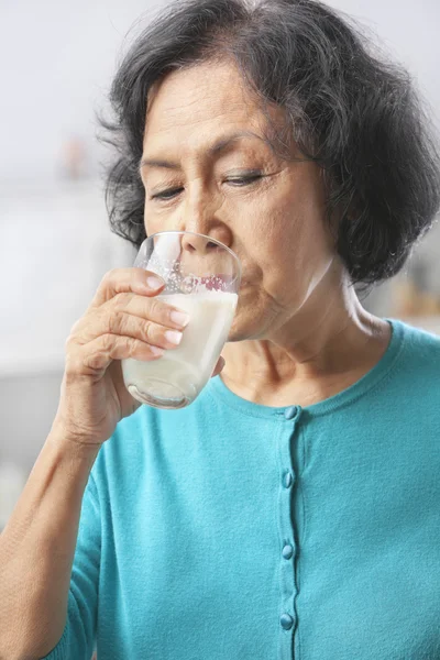 Seniorin trinkt Milch — Stockfoto