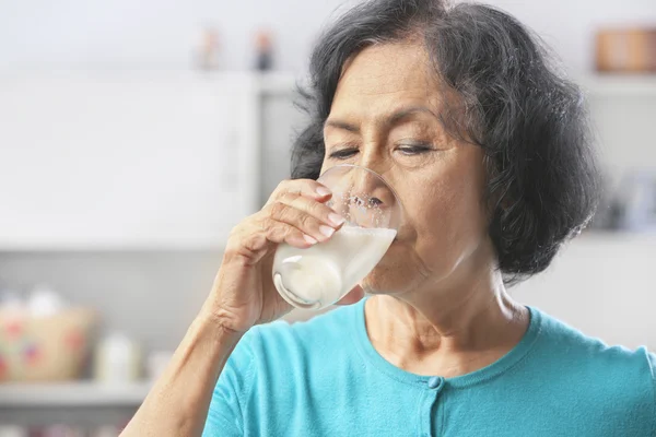 Yaşlı kadın süt içiyor. — Stok fotoğraf