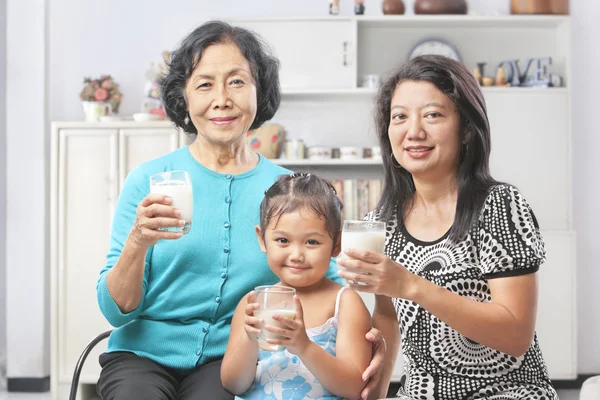 Three female generation holding glass of milk — Stock Photo, Image