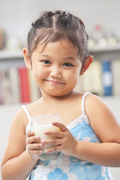 Liten flicka håller glas mjölk — Stockfoto