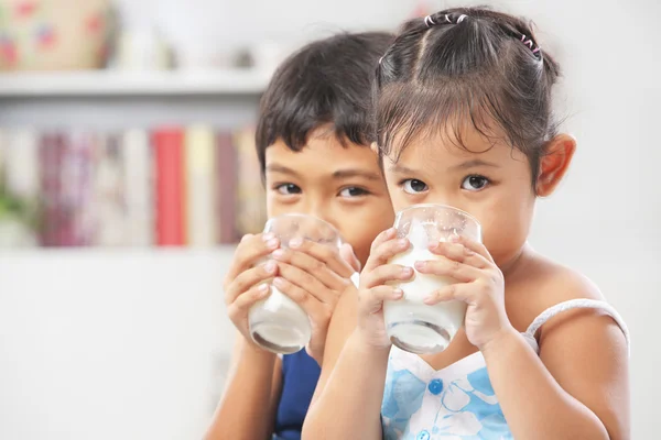 Dos niños y niñas bebiendo leche — Foto de Stock