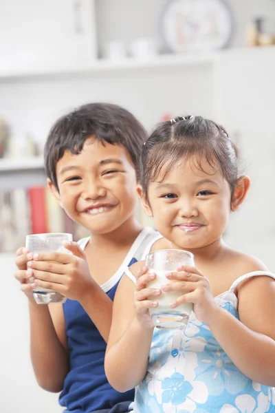 Två liten flicka och pojke håller glas mjölk — Stockfoto