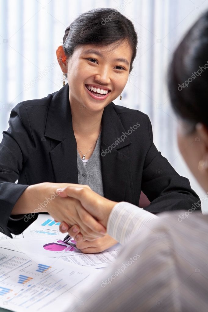 Chinese busineswoman handshake with her client