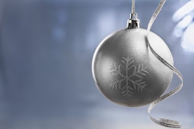 Silver Chrismast ball over blue background clipart