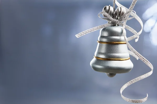 Stříbrný vánoční zvonek nad modrým pozadím — Stock fotografie