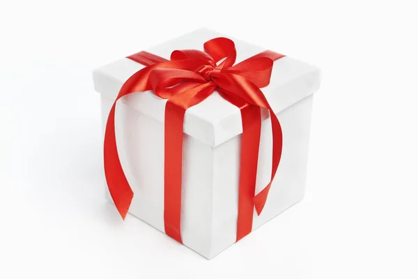 Beyaz bir Noel hediyesi kırmızı kurdele ile — Stok fotoğraf
