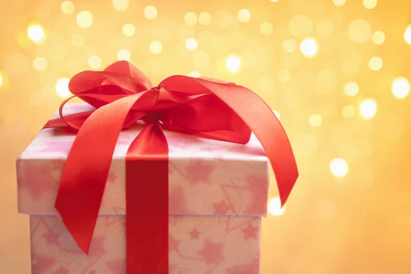 Red Christmas present over blurred light — Stock Photo, Image