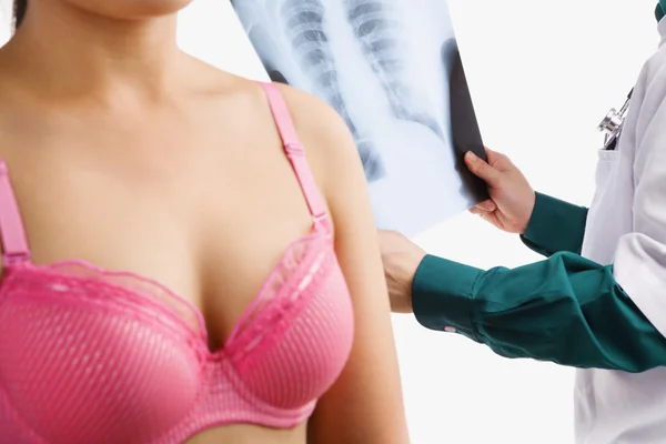 Doctor examine xray with woman on pink bra — Stock Photo, Image