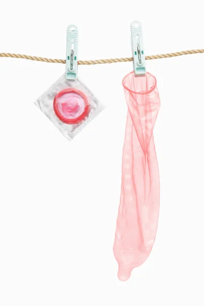 Preservativo pendurado sobre fundo branco — Fotografia de Stock