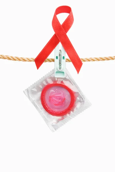 Prezerwatywy wiszące z czerwoną wstążką na białym tle — Zdjęcie stockowe