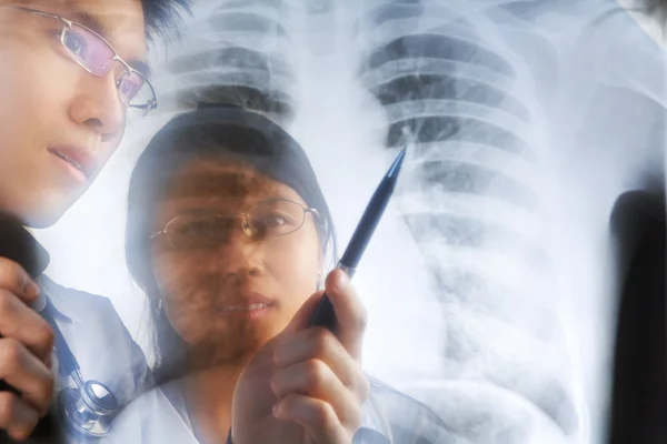 亚洲医生对 x 射线具有讨论打印 — 图库照片