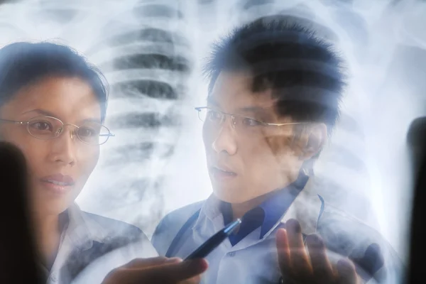 Asijské lékaři mají diskuse nad xray tisk — Stock fotografie