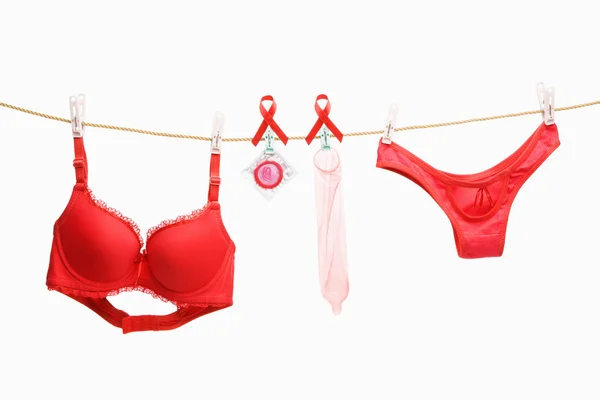 Czerwony underwears, wstążki i prezerwatywy wiszące na lina — Zdjęcie stockowe