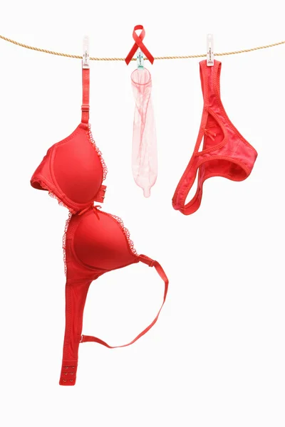 Biancheria intima rossa, nastro e preservativi appesi alla corda — Foto Stock