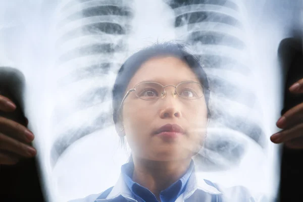 Asiática médico ocupado trabalhando no resultado de raio-x — Fotografia de Stock