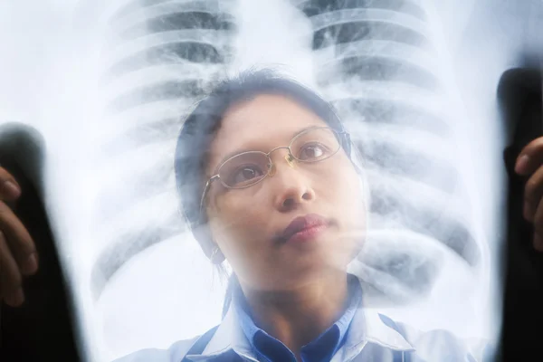 Asiática médico ocupado trabalhando no resultado de raio-x — Fotografia de Stock