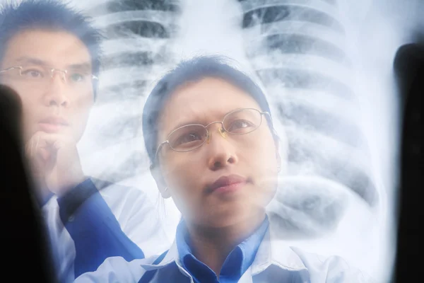 Dvě asijské lékaře vyšetřujícího výsledek RTG — Stock fotografie
