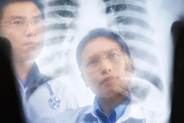Dois médicos asiáticos examinando o resultado do raio X — Fotografia de Stock