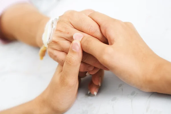 Dotter håller hennes mor hand i sjukhus — Stockfoto