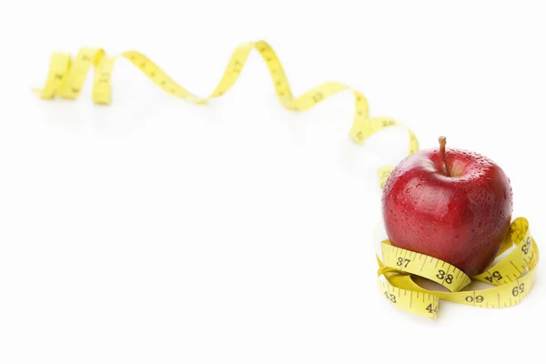 Красное яблоко с измерительной лентой — стоковое фото