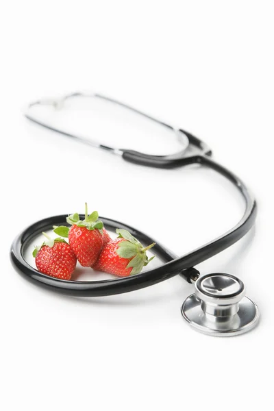 Stethoscope and strawberry over white — Stock Photo, Image