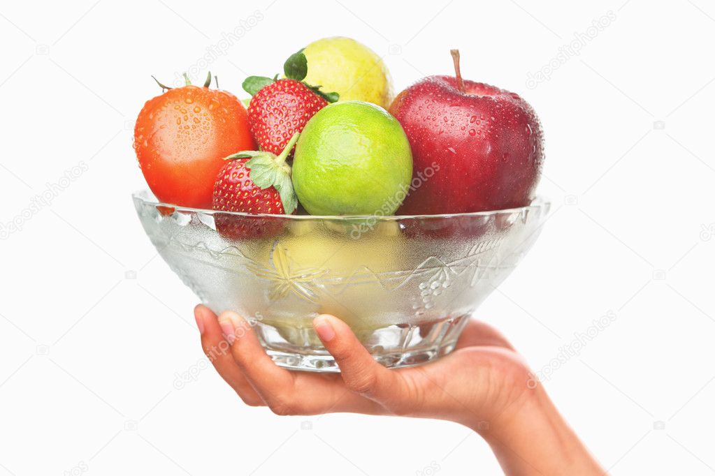 Hand holding bowl of fruits