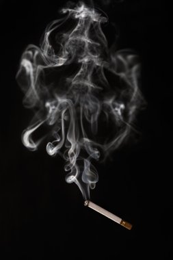 Burning cigarette falling of with smoke having abstract shape clipart