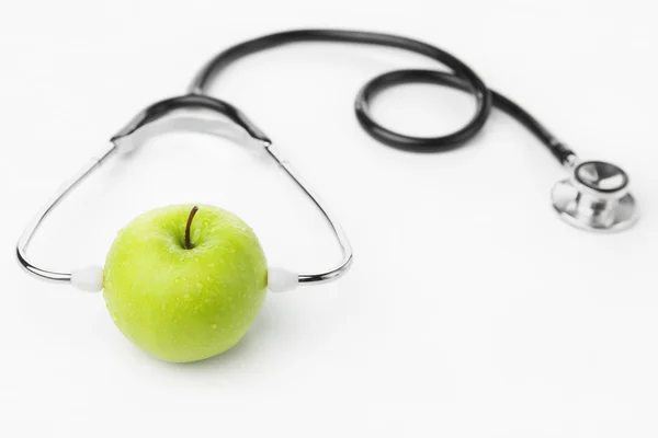 Groene appel stethoscoop dragen over Wit — Stockfoto