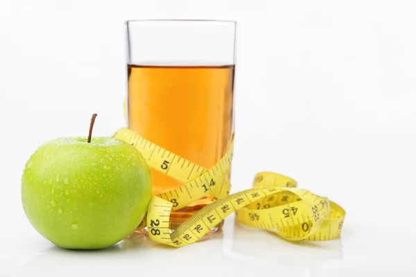 Зеленое яблоко и сок с измерительной лентой — стоковое фото