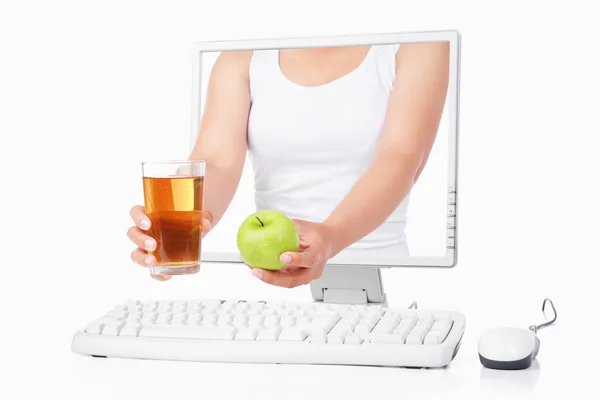 Weibliche Hand mit grünem Apfel und Saft aus dem Computer — Stockfoto