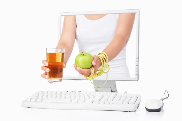 Female hand holding green apple and juice coming out from comput — Stock Photo, Image