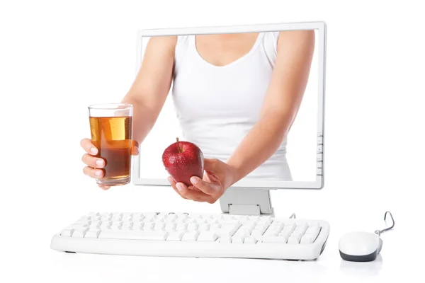 赤いリンゴ、コンピューターから出てくるジュースを持っている女性の手 — ストック写真