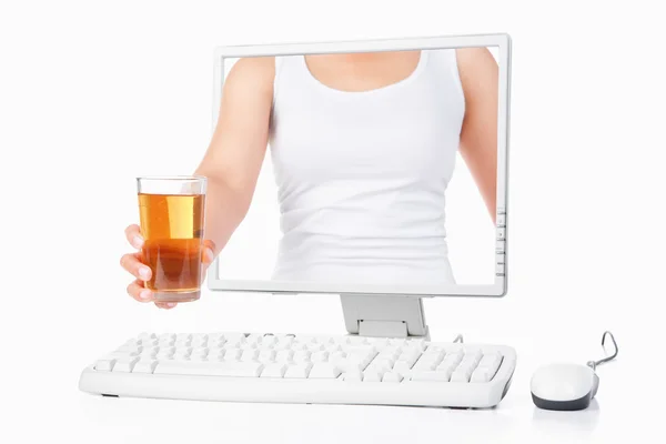 Женщина держит яблочный сок, выходящий с экрана компьютера — стоковое фото