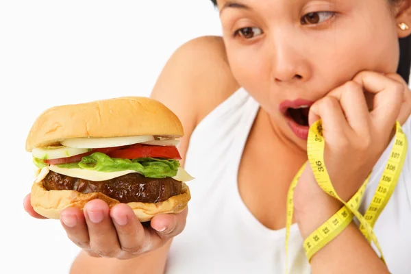 Mujer joven sorprendentemente mirando hamburguesa — Foto de Stock