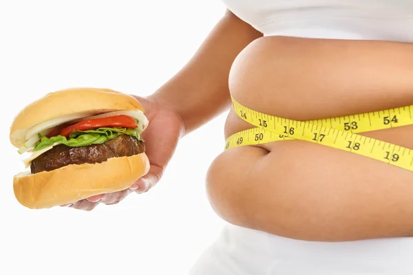 Tłuszcz żołądka otoczone pomiaru taśmę i burger — Zdjęcie stockowe