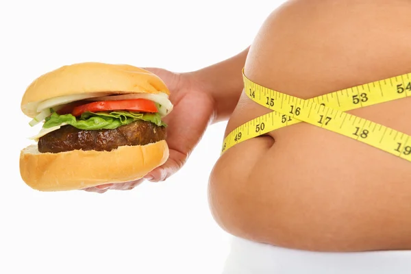Жирний шлунок оточений вимірювальною стрічкою і бургер — стокове фото