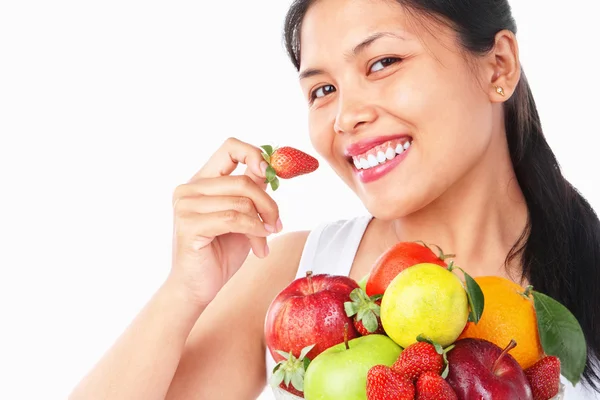Frau hält Erdbeere und Schale mit Früchten — Stockfoto