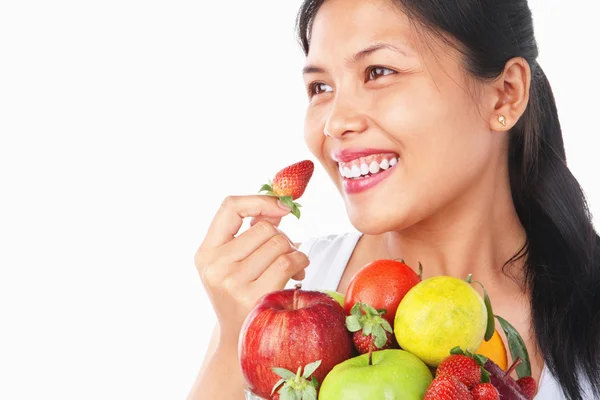 Frau hält Erdbeere und Schale mit Früchten — Stockfoto