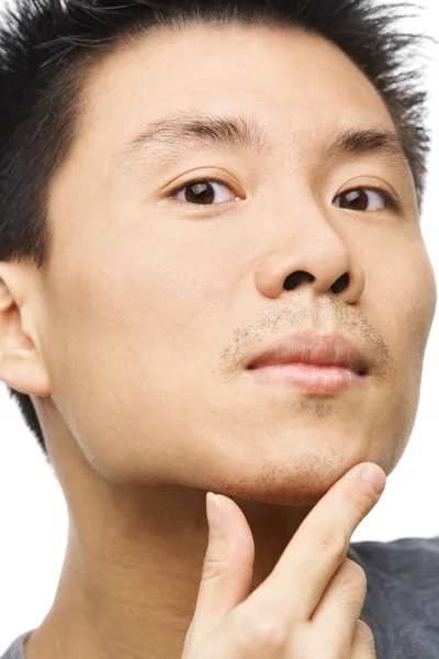 Asian man looking his unshaved chin — Stock Photo, Image