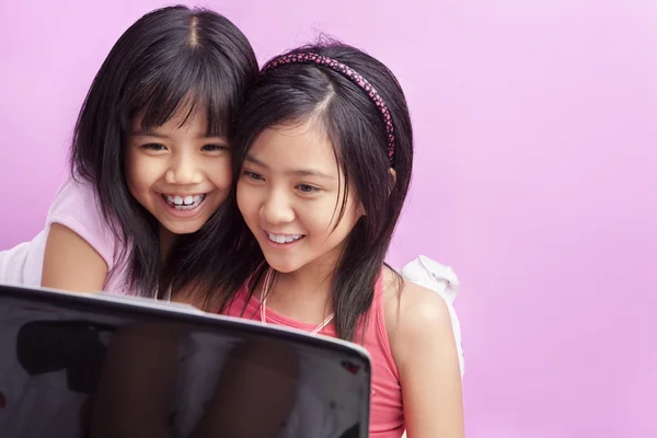 Девочки играют на ноутбуке — стоковое фото