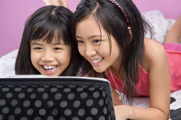 Två små flickor leker med laptop — Stockfoto