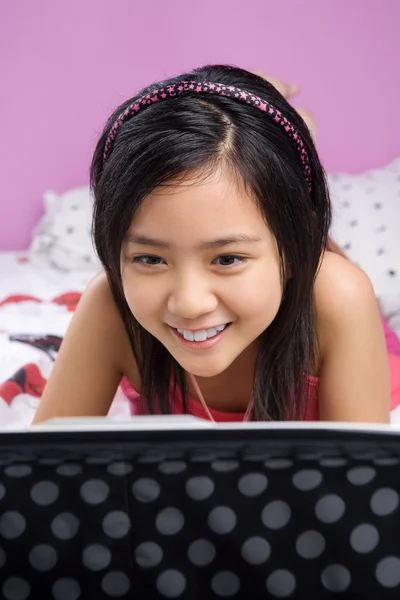 Ung flicka med laptop i hennes sovrum — Stockfoto