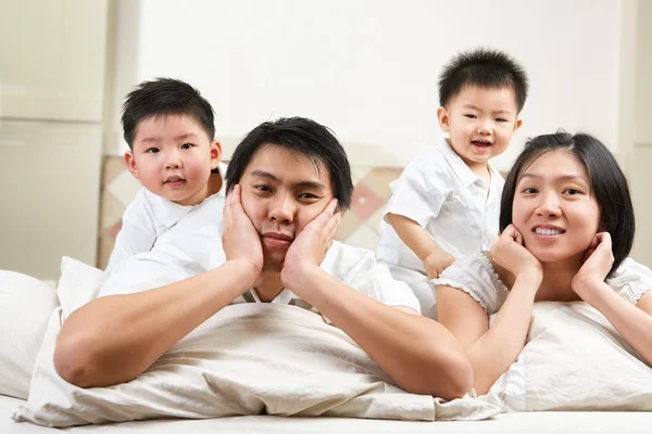 Ázsiai család ágyon — Stock Fotó