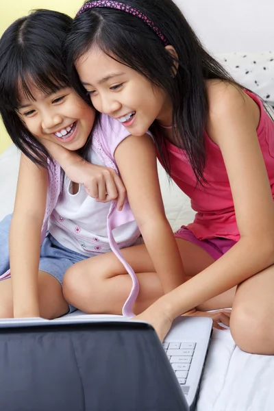 Pienet tytöt käyttävät kannettavaa tietokonetta — kuvapankkivalokuva