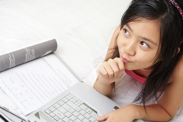Kleine Mädchen spielen Laptop während des Studiums — Stockfoto