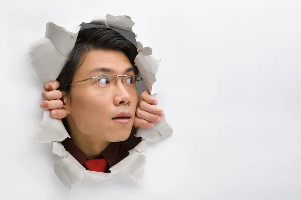 Man looking away to his left side from hole in wall — Stock Photo, Image